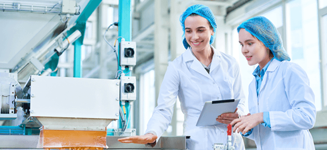 Food-safety staff in hairnets and lab coats inside a licensed human food facility